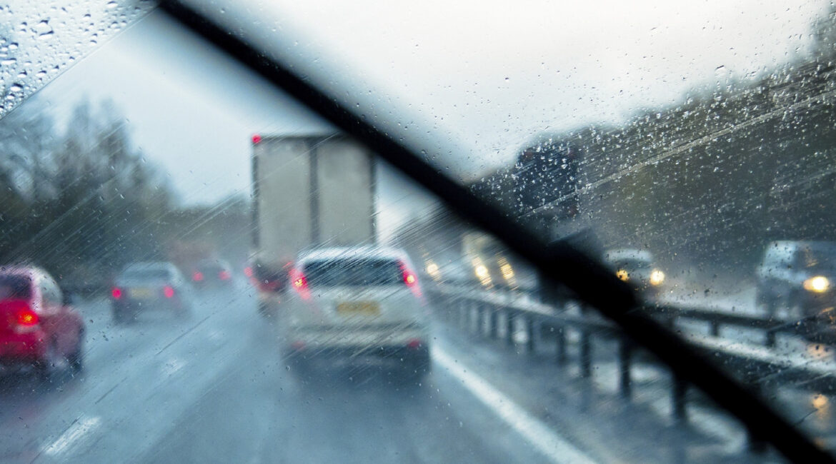 A hire van being driven carefully on a wet Warrington road, demonstrating safe driving techniques for stormy weather and adverse conditions.