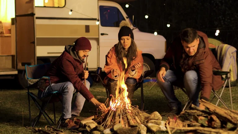 46747018_girl-warming-up-her-hands-while-her-friend-making-the-fire-stronger | Warrington Van Hire | Central Warrington Van Hire | Call 01925 396 222 Bonfire Night Van Hire for Community Displays